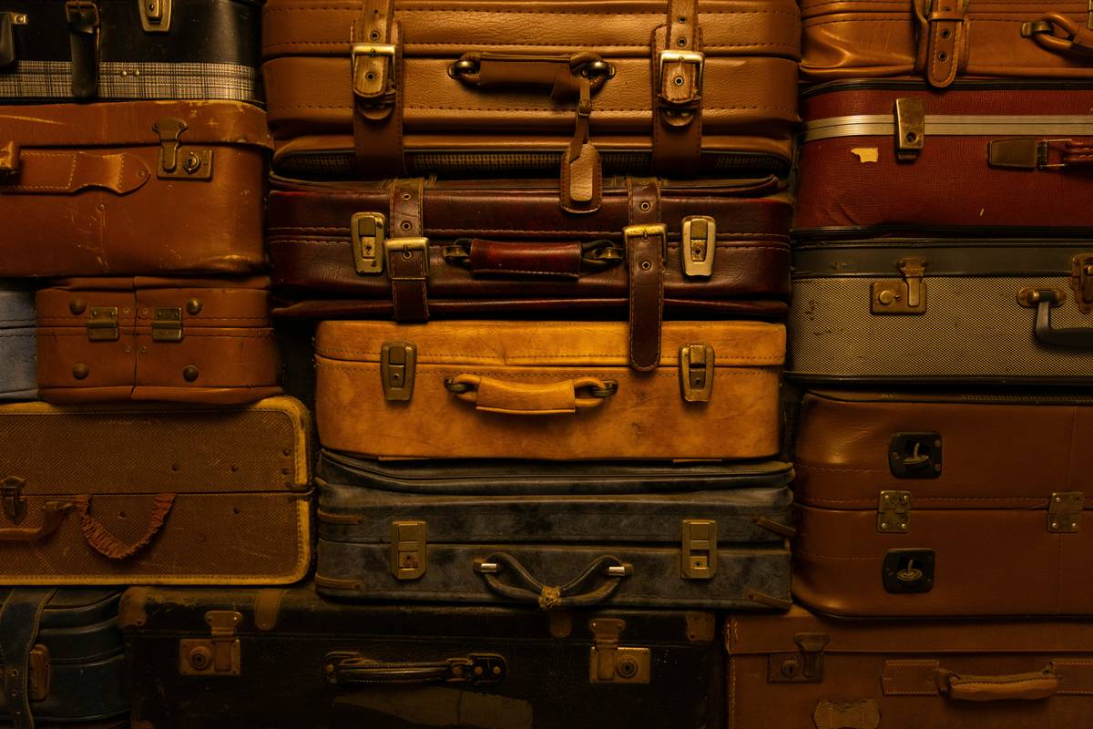Traveler filing Lost Luggage Replacement Process claim at airport counter with documents